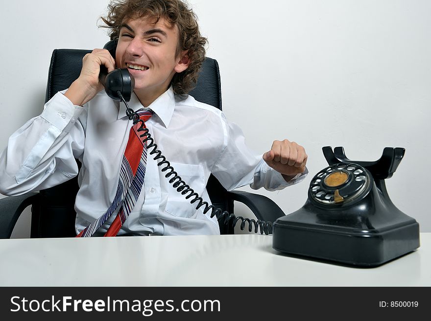 Young business man screaming at an old telephone. Young business man screaming at an old telephone