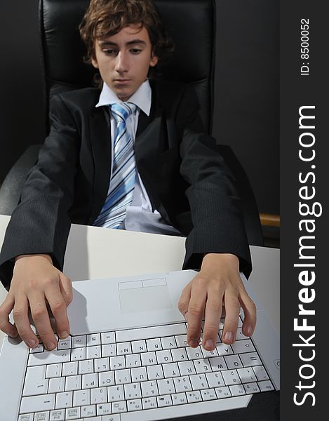 Young businessman at desk using computer laptop. Young businessman at desk using computer laptop