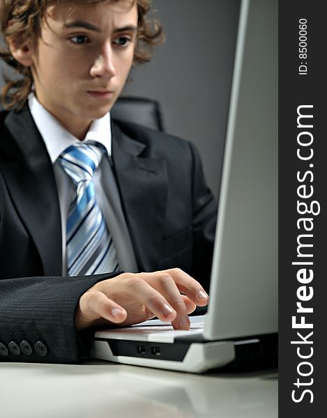 Young businessman at desk using computer laptop. Young businessman at desk using computer laptop