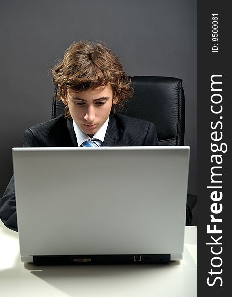 Young businessman at desk using computer laptop. Young businessman at desk using computer laptop