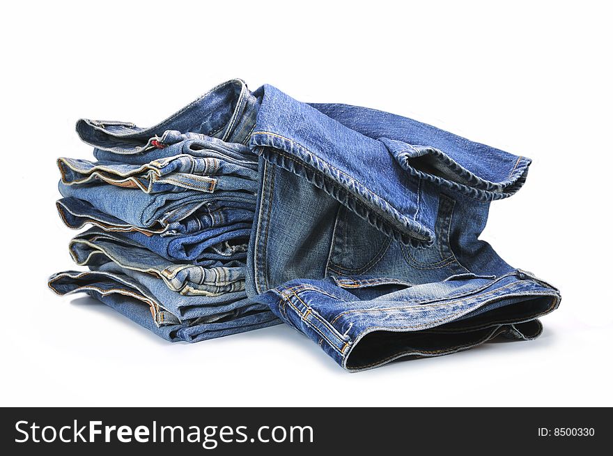 Big bunch of washed-out blue jeans isolated on white background