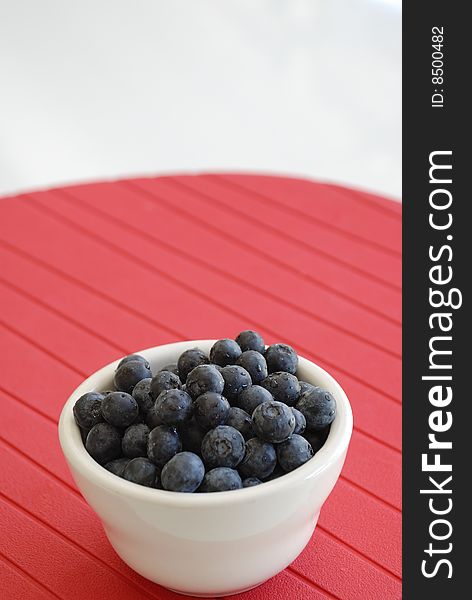 Blueberries In White Bowl Over Red