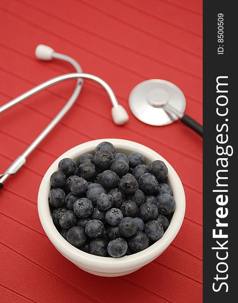 Blueberries and health in white bowl over red