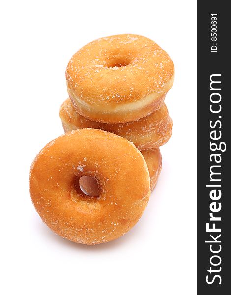 Four sweet donuts stacked on white background.
