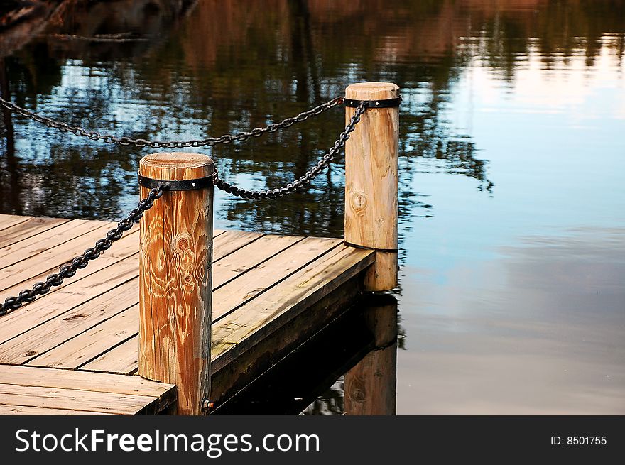 Wooden dock on reflective pond