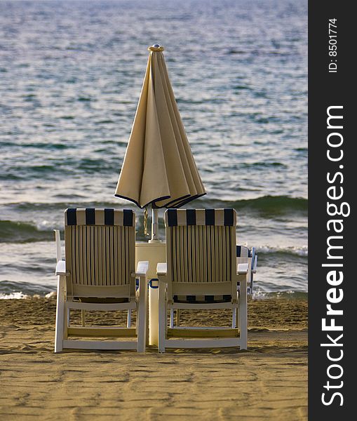 Two beach chairs wait by the sea