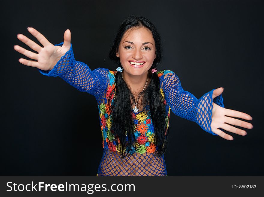 Young pretty woman with outstretched arms on black