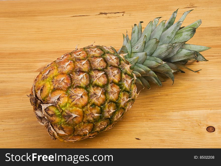 Fresh pineapple placed lying on a wood table,check also <a href=http://www.dreamstime.com/healthy-food-rcollection8217-resi828293>Healthy food</a>