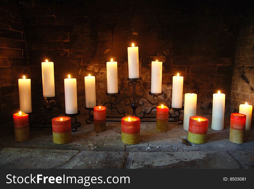 Tall candles arranged in an open fireplace. Tall candles arranged in an open fireplace