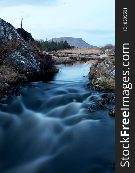 A cascading river with a wooden bridge. A cascading river with a wooden bridge