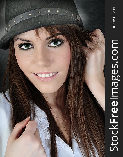 Female model wearing a hat smiling at the camera holding her hair in her fingers. Female model wearing a hat smiling at the camera holding her hair in her fingers.