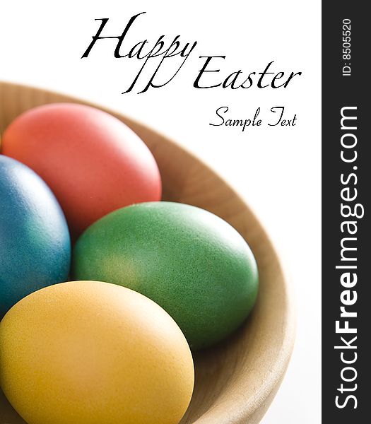 Colorful easter eggs in wooden bowl. Space for your text.