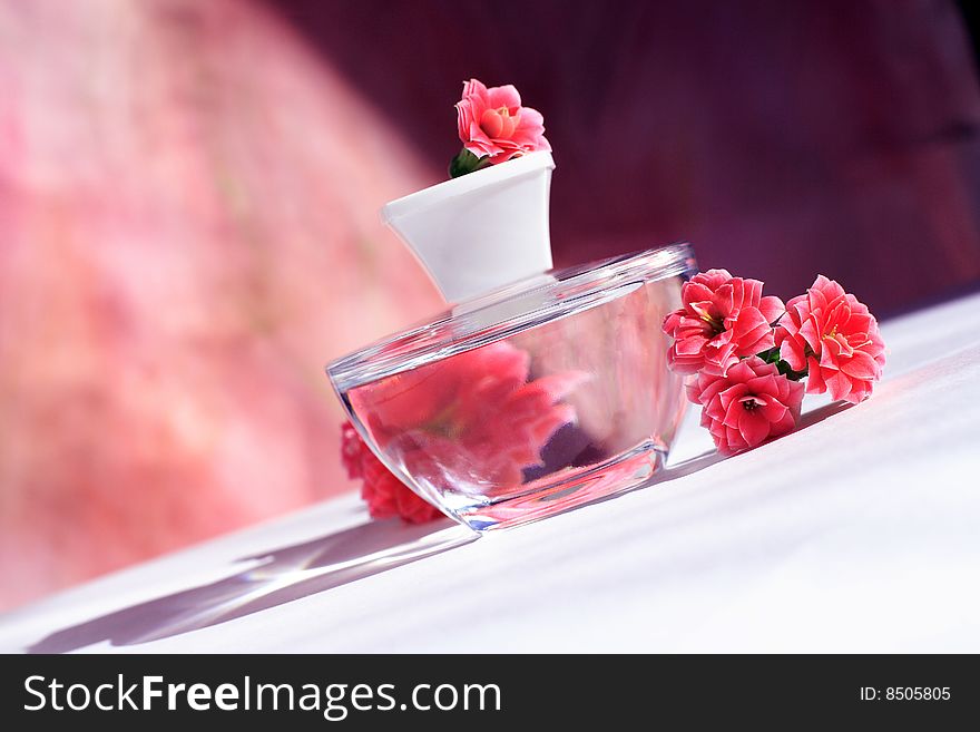 Perfume bottle with red flowers with reflection. Perfume bottle with red flowers with reflection