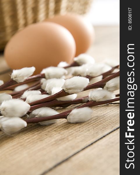 Easter eggs, some catkins and basket in background on wooden boards. Easter eggs, some catkins and basket in background on wooden boards.