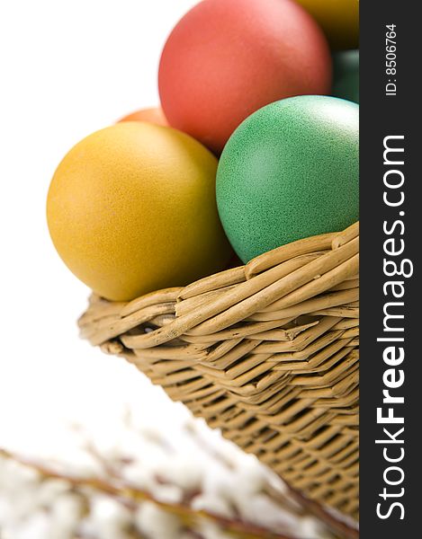 Colorful easter eggs in basket. Some catkins in background. Colorful easter eggs in basket. Some catkins in background.