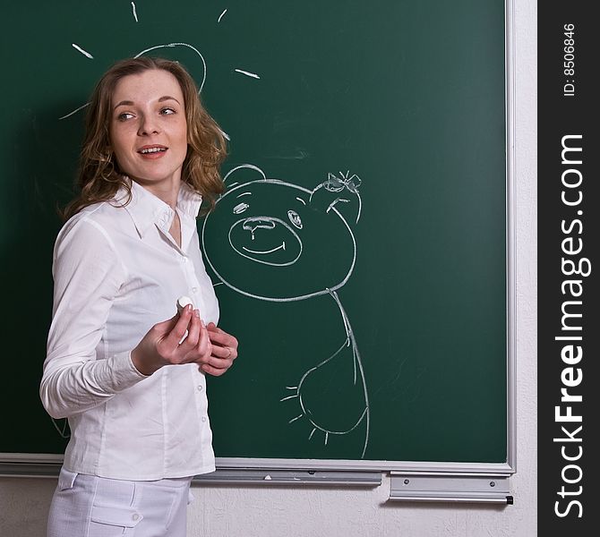Young woman is drawing the animal on the blackboard, looking, happy. Young woman is drawing the animal on the blackboard, looking, happy.