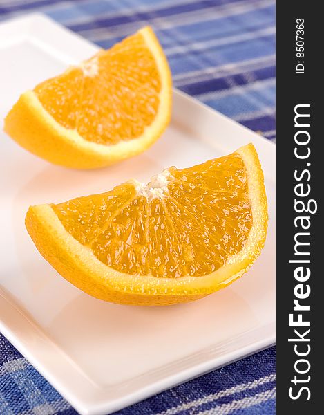 Sliced oranges on a white plate with selective focus