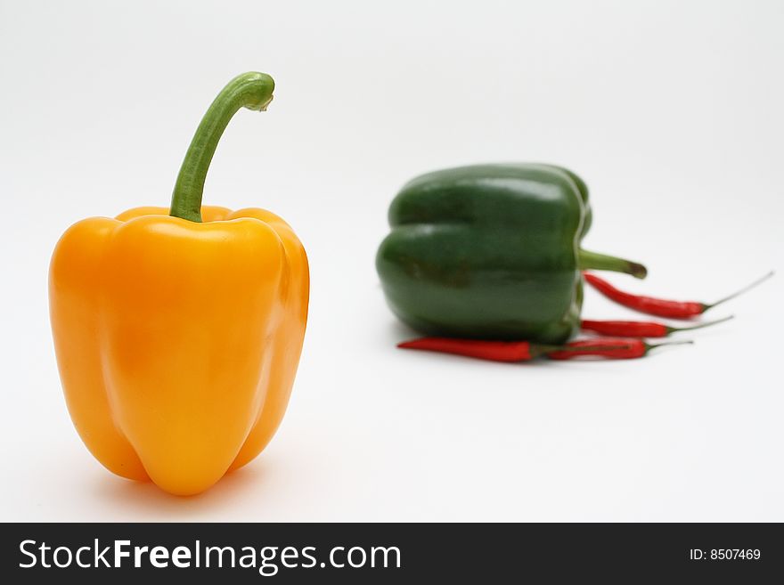 Orange, green and red pepper on white background