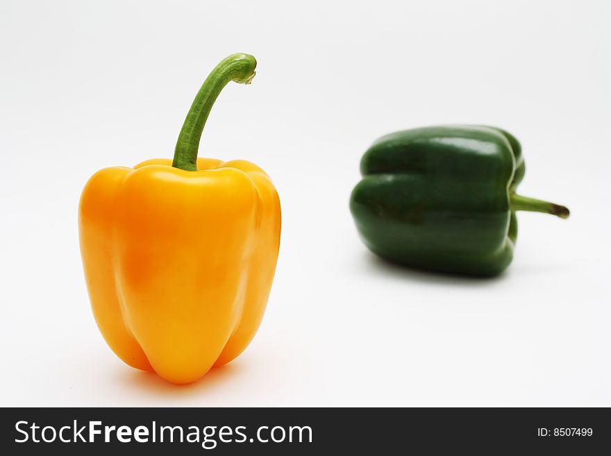 Orange and green pepper on white background