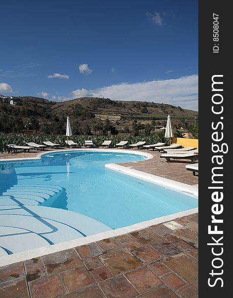 Beautiful swimming pool surrounded by chairs and plants