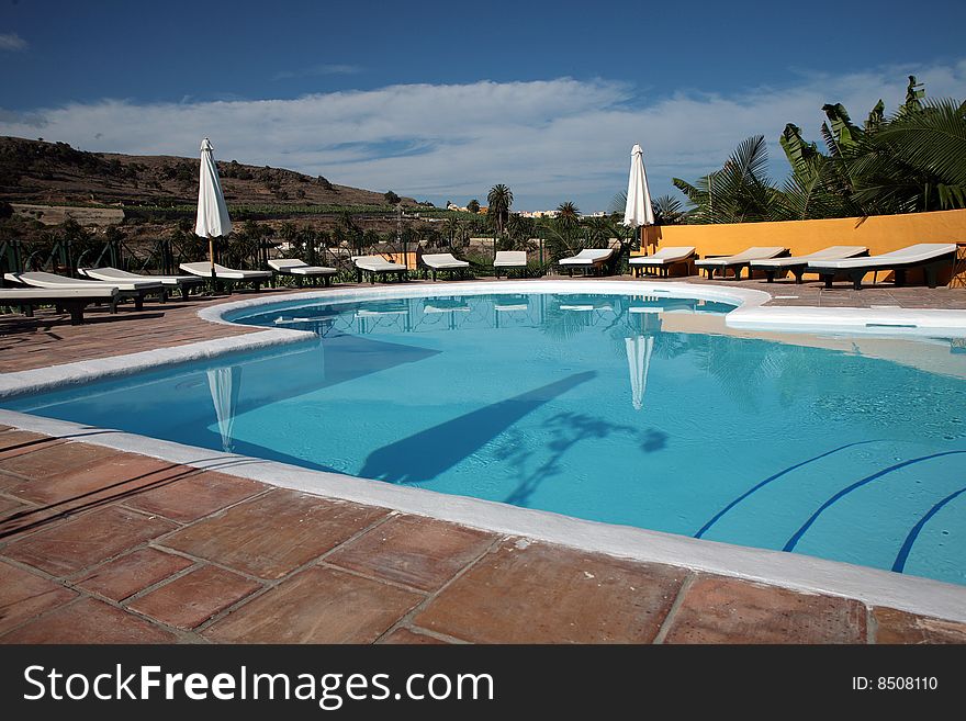 Beautiful swimming pool surrounded by chairs and plants