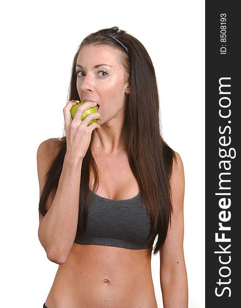 Fitness woman biting an apple isolated on white