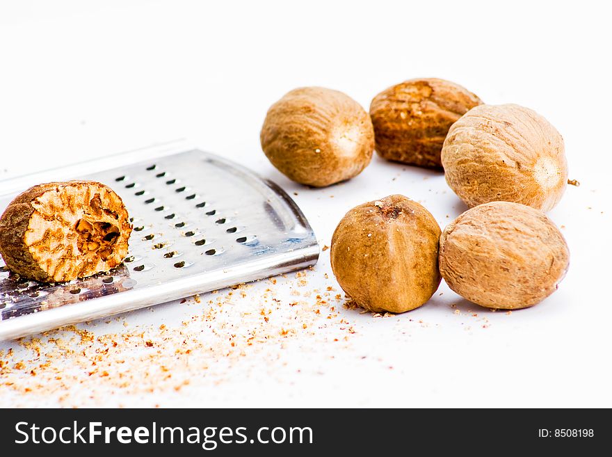 Several nutmegs with grater and fresh shavings. Several nutmegs with grater and fresh shavings