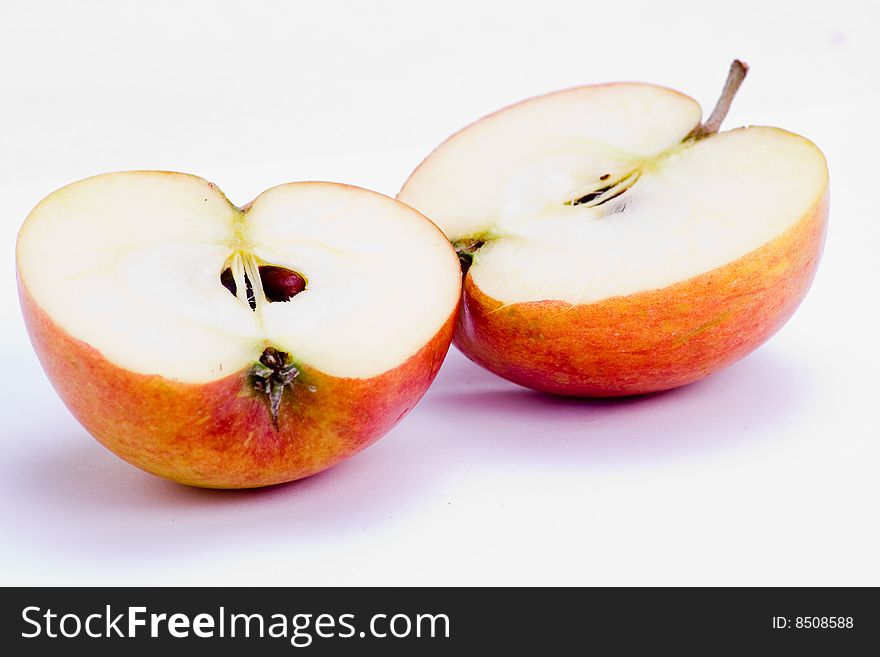 A freshly halved apple over white background