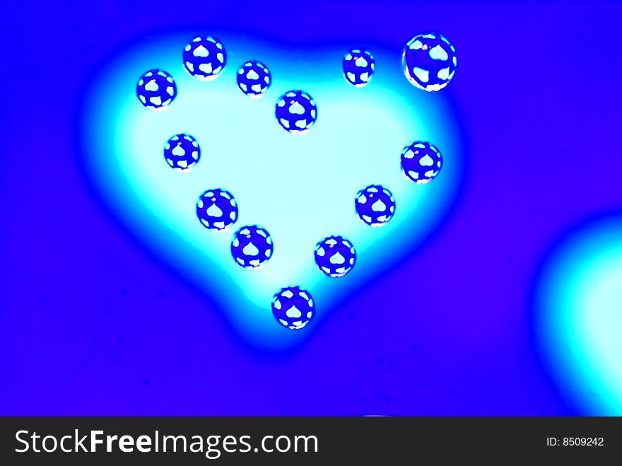 Water drops in the form of heart on a multi-coloured celebratory background