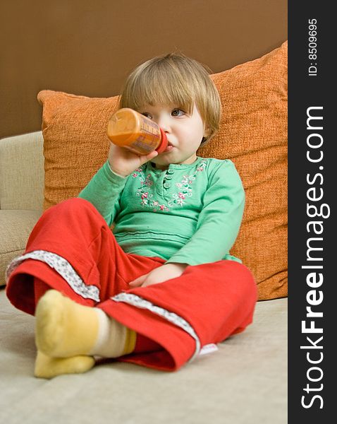 Sweet baby girl drinking on sofa. Sweet baby girl drinking on sofa