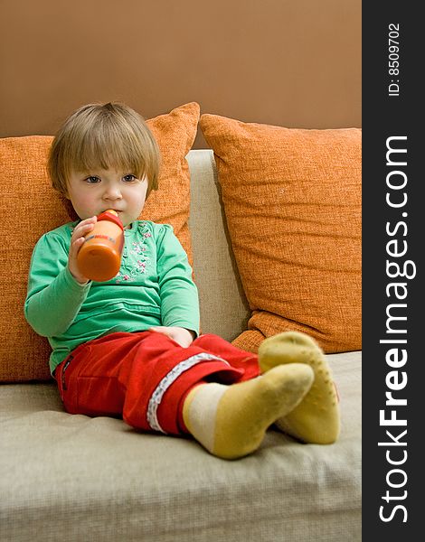 Sweet baby girl drinking on sofa. Sweet baby girl drinking on sofa