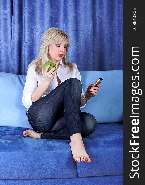 Girl with apple calling by phone in room