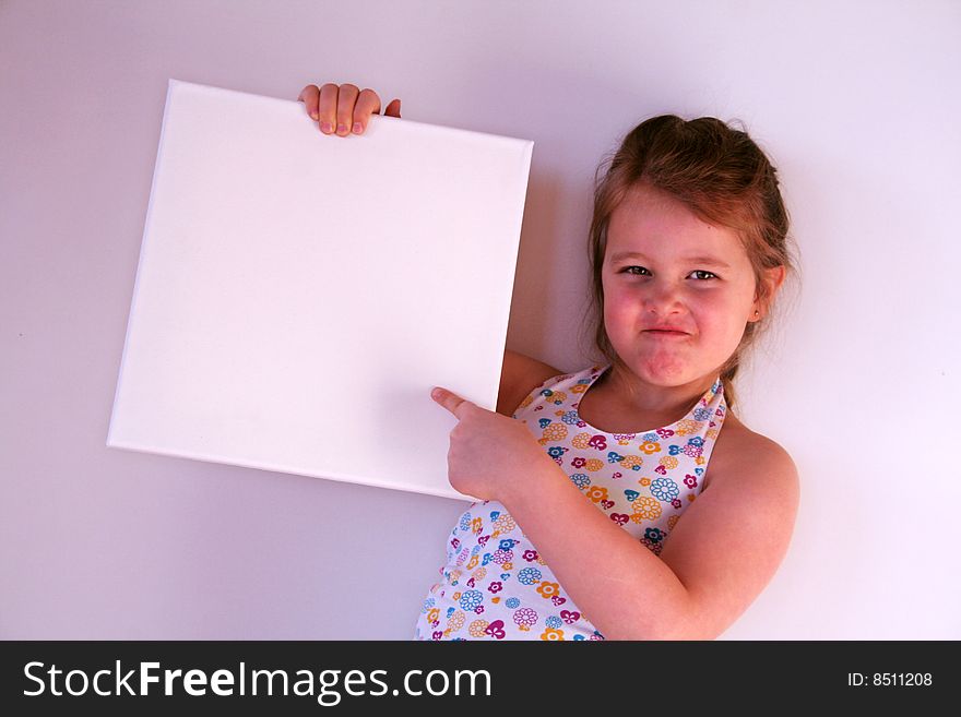 A girl is holding a white frame in her hands. A girl is holding a white frame in her hands