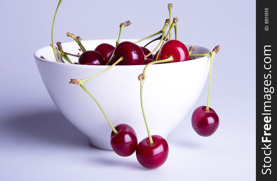 Big red cherries in bowl on white background