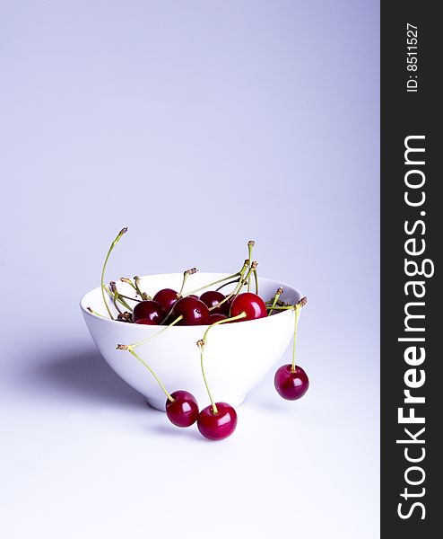 Big red cherries in bowl on white background