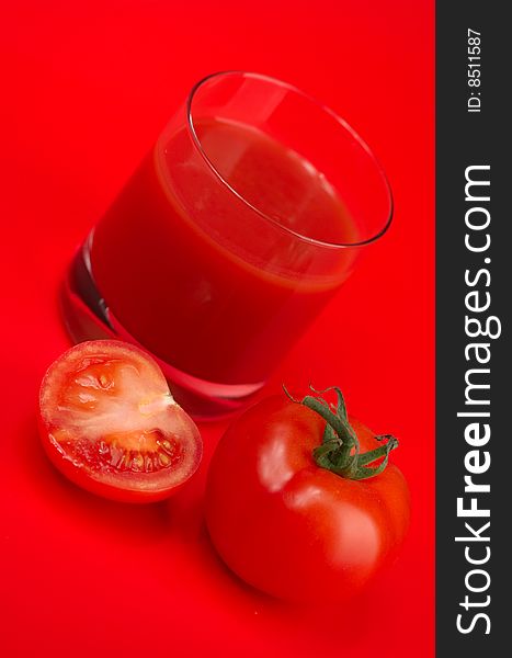 Fresh tomato juice and ripe tomatoes on a red background. Fresh tomato juice and ripe tomatoes on a red background