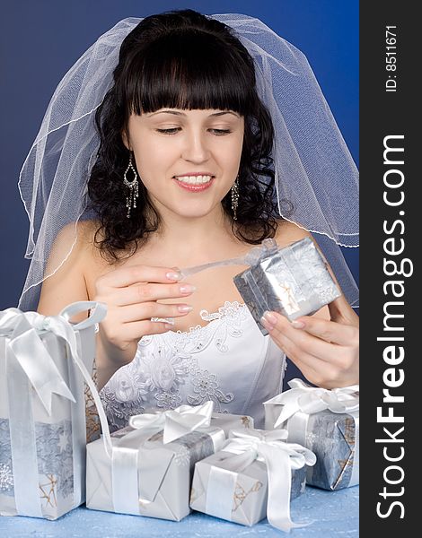 Studio portrait of a beautiful brunette bride with presents