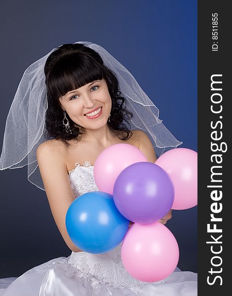 Studio portrait of a beautiful brunette bride with balloons