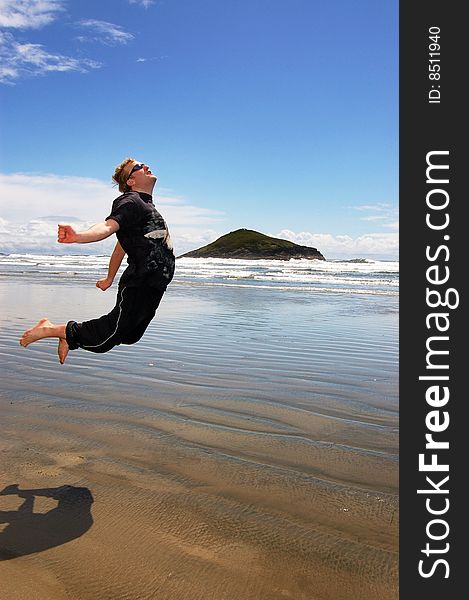 Man is jumping on a beautiful beach. Long Beach, Tofino, Canada. Man is jumping on a beautiful beach. Long Beach, Tofino, Canada.