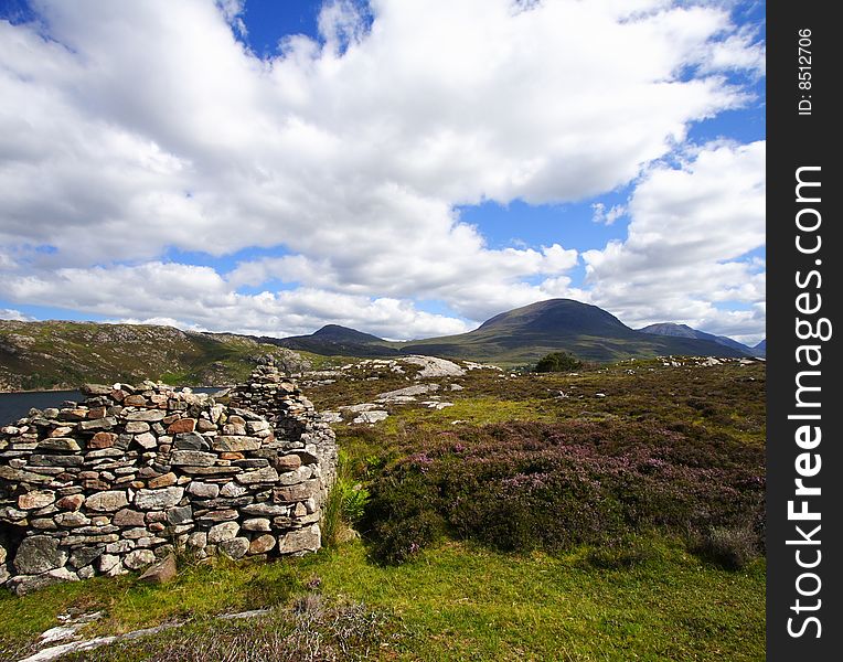 Old stoned ruin and highlands landscape with heather by a sunny summer day. Old stoned ruin and highlands landscape with heather by a sunny summer day