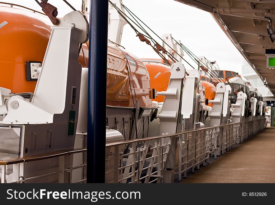 Lifeboats on a cruise ship along a walkway. Lifeboats on a cruise ship along a walkway