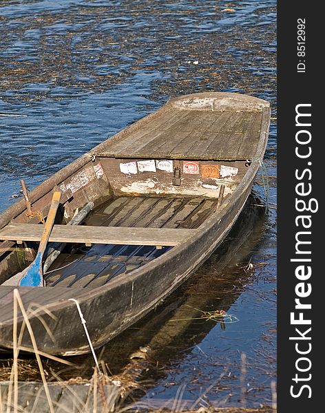 A boat which is frozen in the lake with a meditative beautiful mood in a romantic winter landscape. A boat which is frozen in the lake with a meditative beautiful mood in a romantic winter landscape