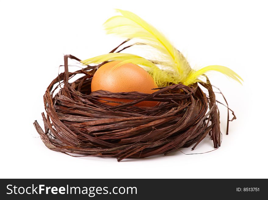 Egg in the nest with yellow feathers, isolated on white. Egg in the nest with yellow feathers, isolated on white