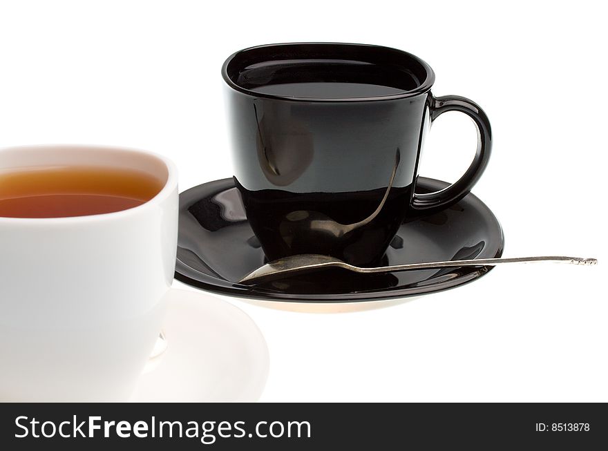Close-up white and black cups with tea, isolated