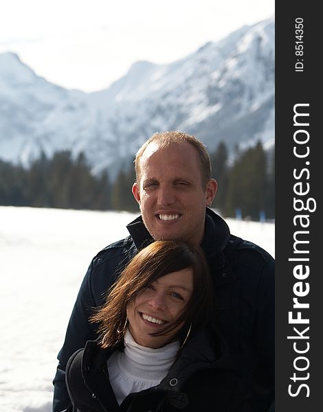 A young couple outdoor in a winter setting. The couple is hugging each other. A young couple outdoor in a winter setting. The couple is hugging each other.