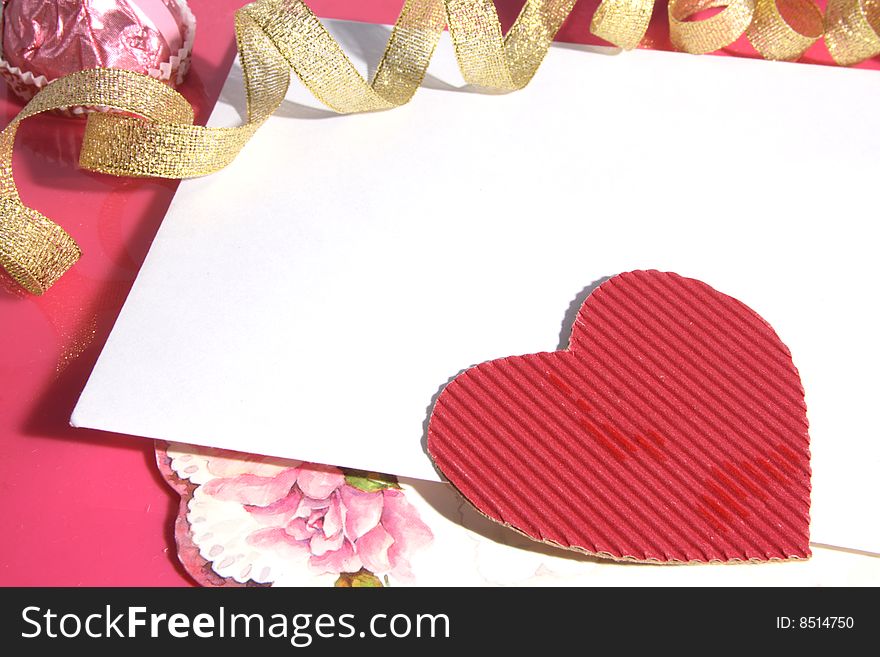 Background with cardboard heart of red color and a gold tape.