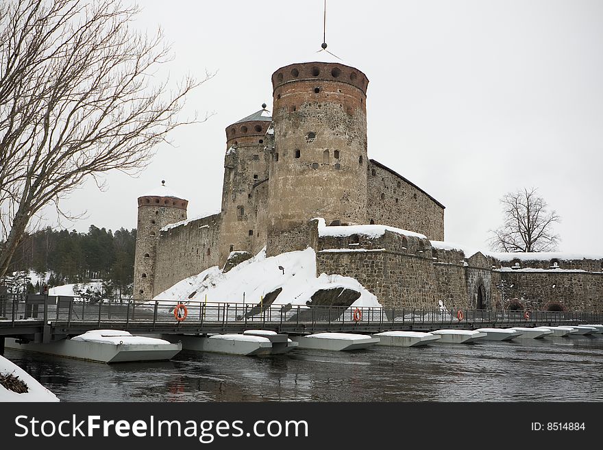 Old castle with stone turrets on lake.