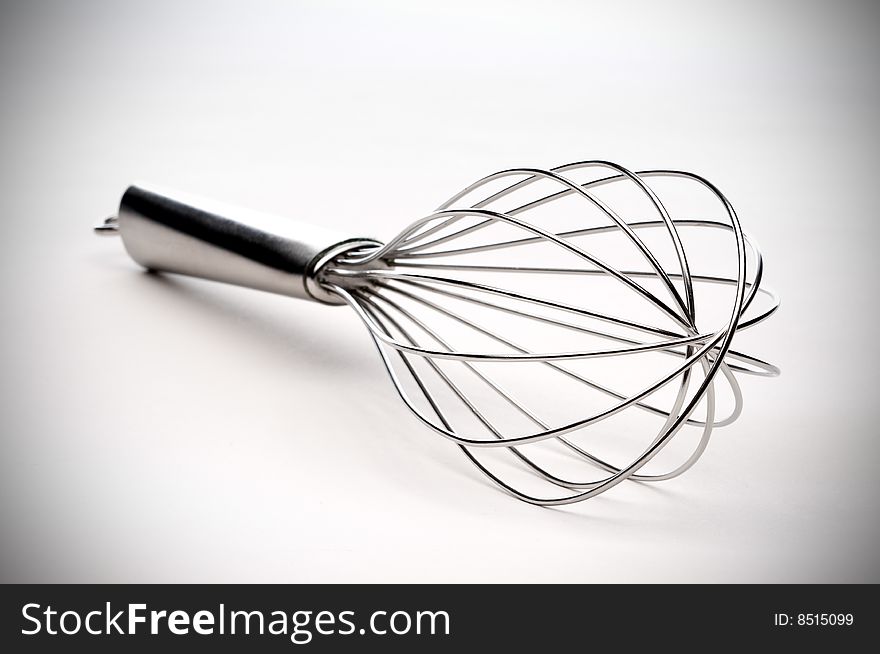 Shallow focus closeup of a silver kitchen whisk with vignette