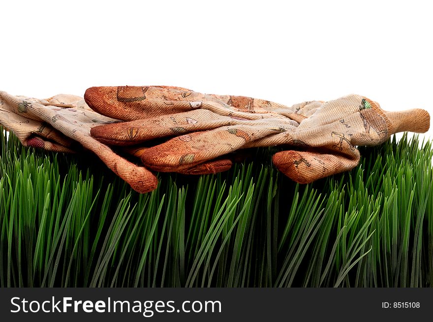 A horizontal view of old worn workgloves on green grass