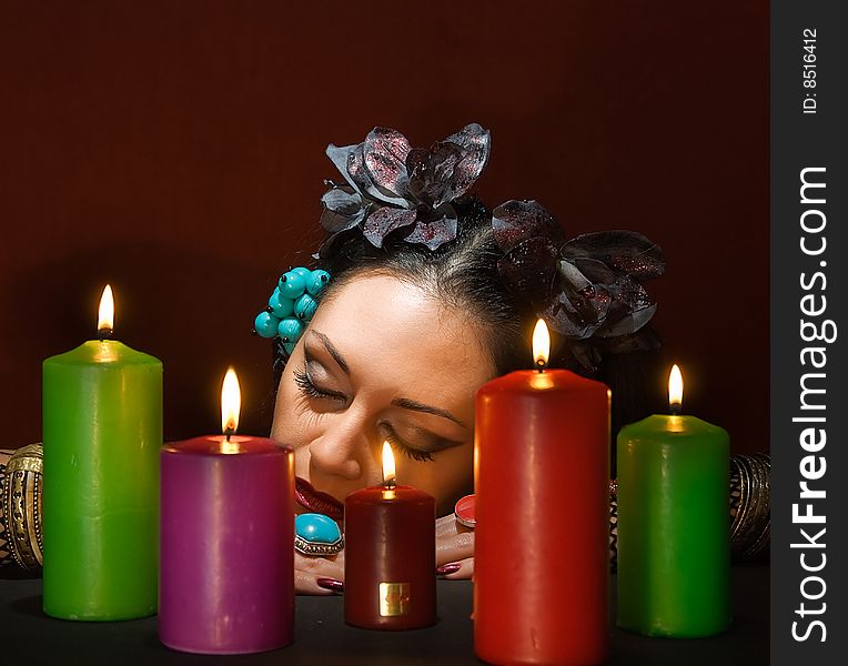 Young beautiful soothsayer sleeps about  five candles. Young beautiful soothsayer sleeps about  five candles